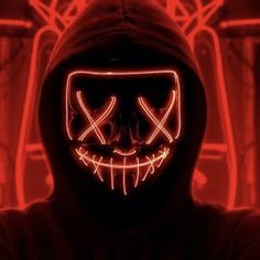 a person wearing a scary mask with red lights on their face in front of them