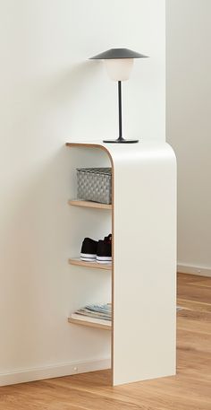 a lamp is on top of a shelf in a room with wood floors and white walls