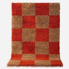 an orange and brown checkered rug on a white background with no one in it