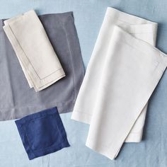 four different colored linens laid out on a blue surface