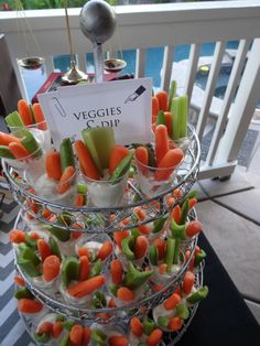 carrots and celery are arranged in cups on a table with a sign