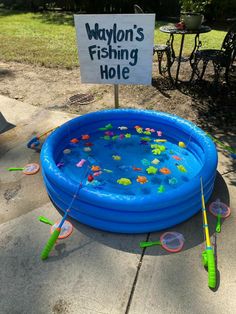 an inflatable swimming pool with fishing holes on the ground and a sign that says, waylon's fishing hole