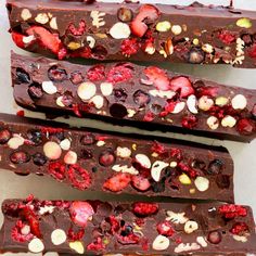 three pieces of chocolate with fruit and nuts on top