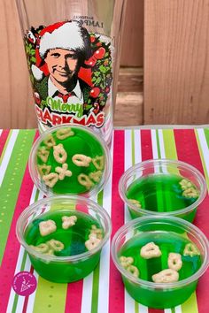 four plastic cups filled with green food on top of a table