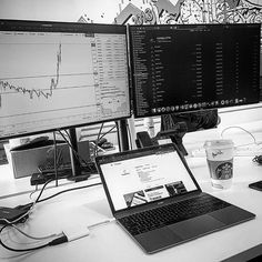 two computer monitors sitting next to each other on top of a desk in front of a laptop