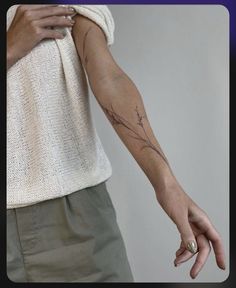 a woman's arm with a flower tattoo on the left side of her hand