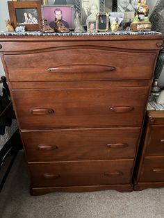 a wooden dresser with many pictures on it