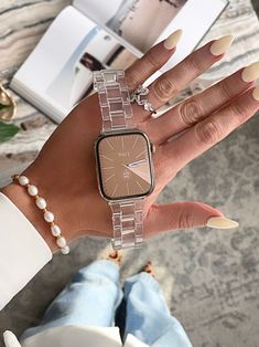 a woman's hand with a watch on it and pearls around her bracelets