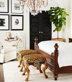 a bedroom with a bed, chandelier and pictures on the wall