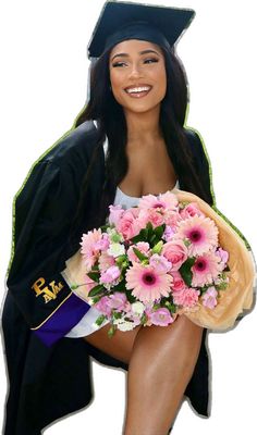 a woman in graduation cap and gown holding a bouquet of pink flowers on her knees