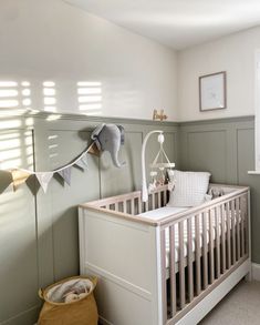 a baby's room with an elephant head hanging on the wall and a crib