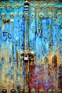 an old blue door with rusted metal handles