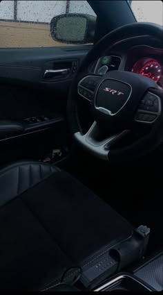 the interior of a car with black leather seats and steering wheel, dashboard lights and dash board