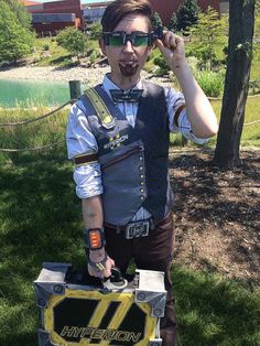 a man dressed up as a construction worker holding a tool box in front of his face