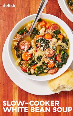 a white bowl filled with soup next to a piece of bread on top of a wooden table