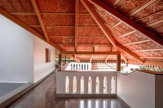 the inside of a building with wooden roof and white railings