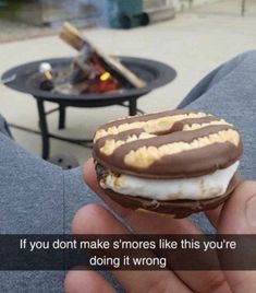 someone is holding a chocolate covered donut with marshmallows on it and the caption reads, if you don't make s smores like this you're doing it wrong