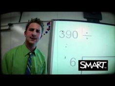 a man in a green shirt and tie standing next to a whiteboard with numbers on it