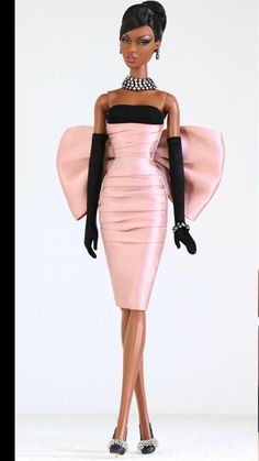 a barbie doll wearing a pink dress and black gloves