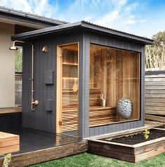 an outdoor saunace in the middle of a yard with grass and wooden steps