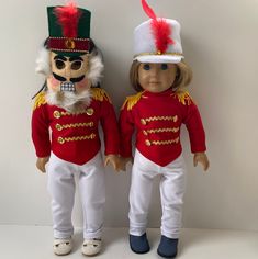 two dolls are dressed in red and white outfits, one is wearing a nutcracker