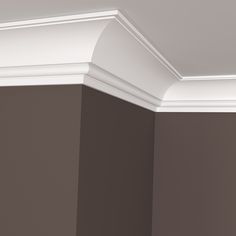 the corner of a room with brown walls and white molding on the trimming