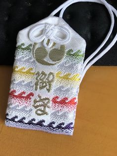 a white bag with chinese writing on it sitting on top of a wooden table next to a black wall