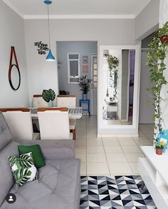 a living room filled with furniture and plants