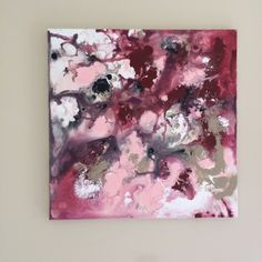 an abstract painting on a wall with white and pink colors in the background, it looks like something out of space