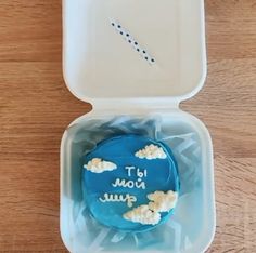 a blue cake in a plastic container with writing on it that says it's now june