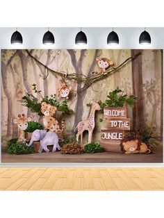 an animal themed backdrop is displayed in front of a wall with animals on it and welcome to the jungle sign