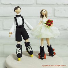 a cake topper that has two people on roller skates and one is wearing a tuxedo