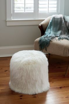 a chair and ottoman in front of a window