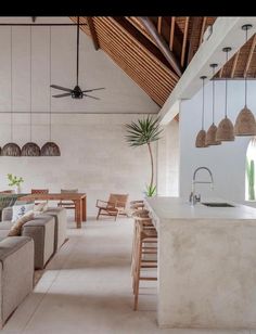 a living room filled with furniture next to a kitchen and dining area in front of an open floor plan