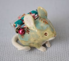 a ceramic mouse figurine with ornaments on its back