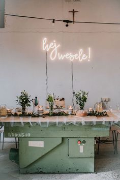 a table topped with lots of food under a neon sign that says we sweee