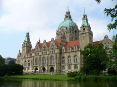 an old building with two towers next to a body of water in front of it