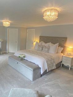 a bedroom with a large bed and chandelier