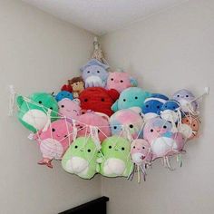 a bunch of stuffed animals are hanging from the ceiling in a room with white walls