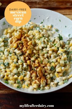 a white bowl filled with corn on top of a wooden table