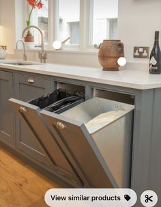 an open dishwasher sitting in the middle of a kitchen next to a sink