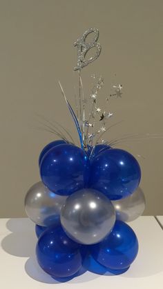 blue and silver balloons are arranged in a vase