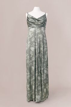 a dress on a mannequin with white flowers in the front and green back