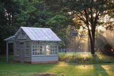 a small shed sitting on top of a lush green field