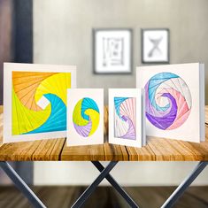 three greeting cards with different designs on them sitting on a table next to each other