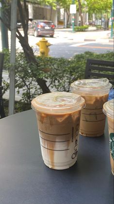 two cups of iced coffee sitting on top of a table