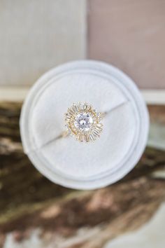 an engagement ring sits on top of a white box with a diamond in the center