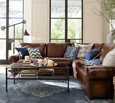 a living room filled with lots of furniture and decor on top of a blue rug