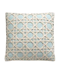 a light blue and white pillow with an intricate design on the front, side and back