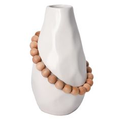 a white vase with some wooden beads on it